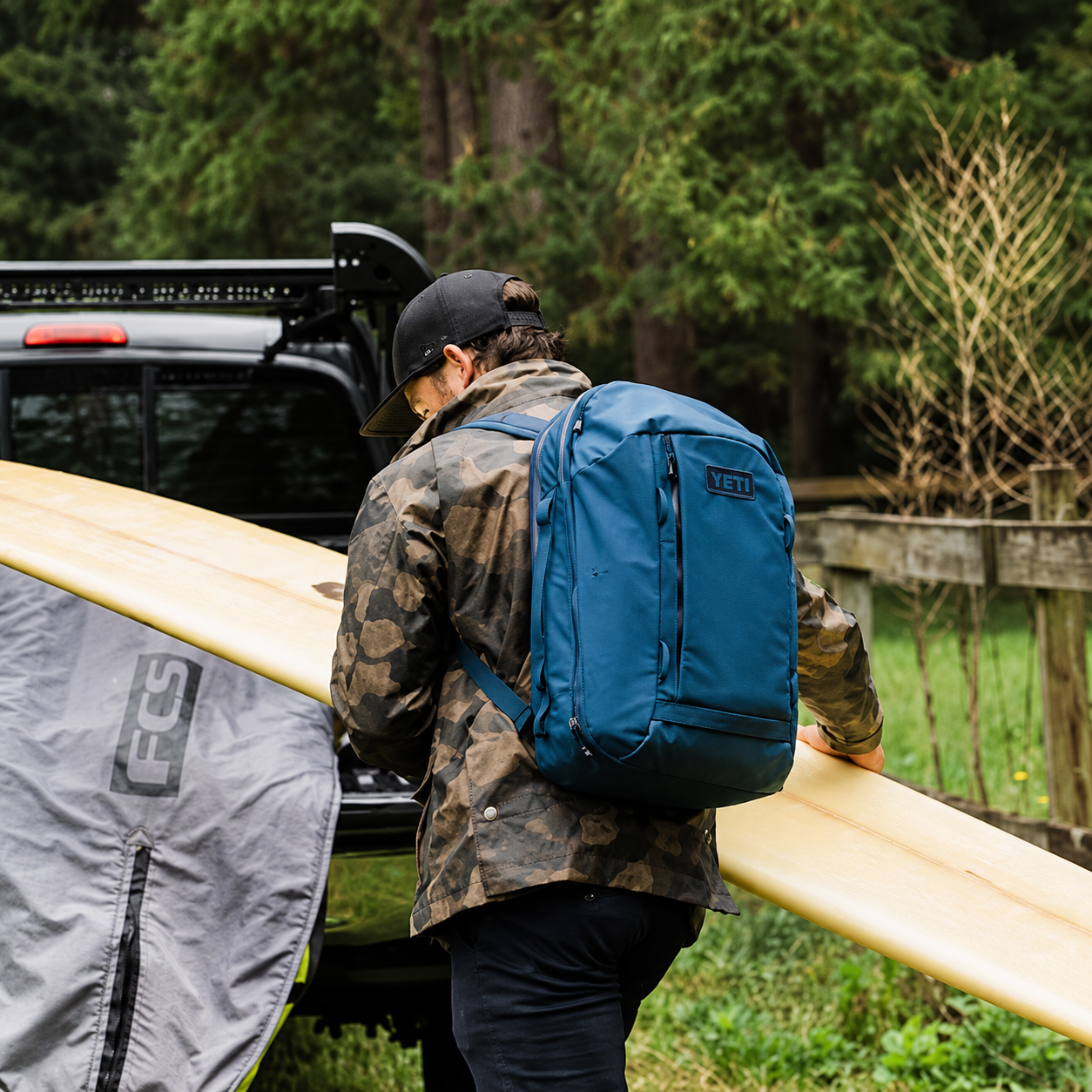 YETI Crossroads 27L Backpack carried with a surfboard
